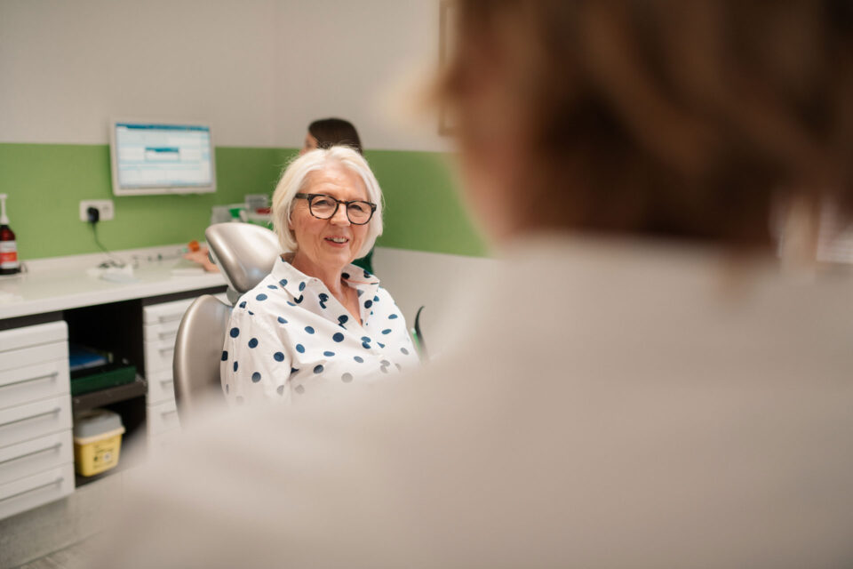 Patientin lacht zu Zahnärztin
